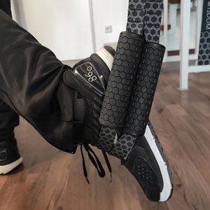 Man using the Body Wisdom Sling Trainer in the foot craddle mode - one foot in two foot craddles