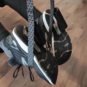 Man using the Body Wisdom Sling Trainer in the foot craddle mode - two feet- on ein each foot craddles