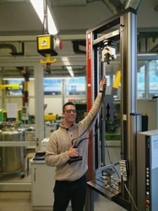 Sven the founder of the Body Wisdom Sling Trainer performing a breaking strength test using a machine in the laboratory of a german university of applied science